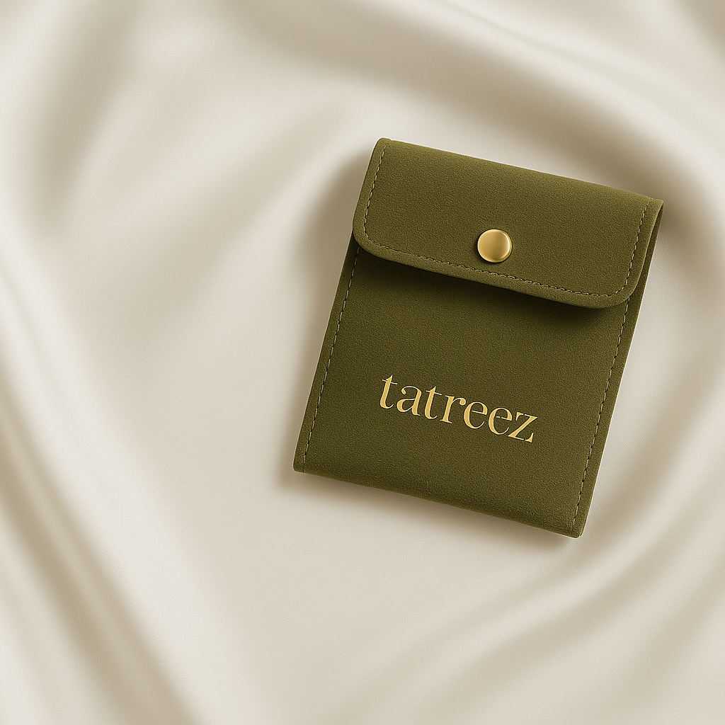 Green pouch with 'tatreez' branding on a beige fabric background