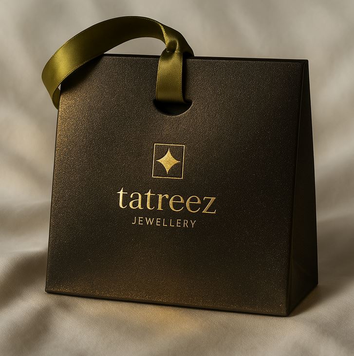 black gift bag with olive green ribbon handle and 'tatreez Jewellery' logo on a beige background